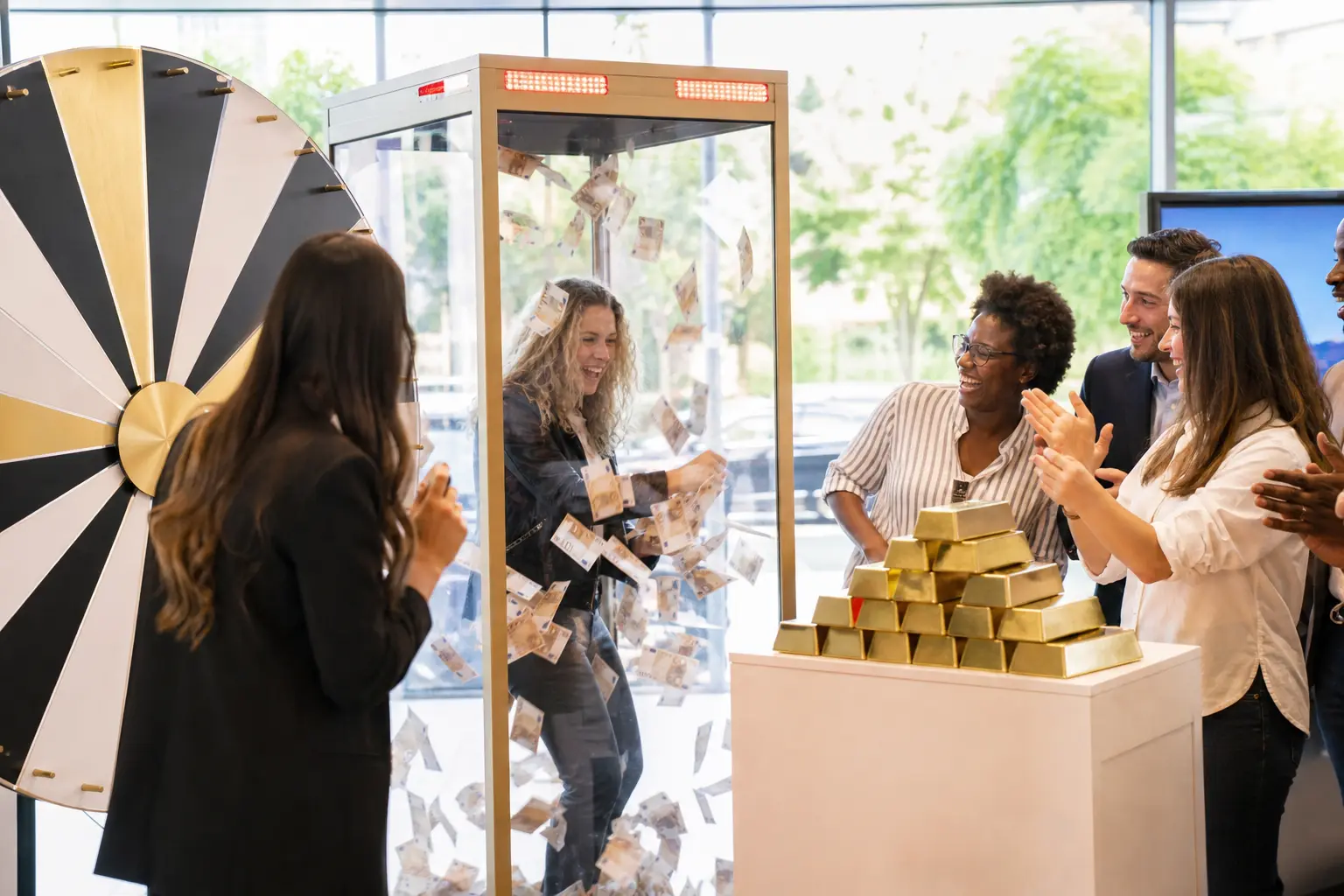 Participants applaud une cabine à billets avec pluie de billets et roue de lots lors d’un lancement de produit en magasin